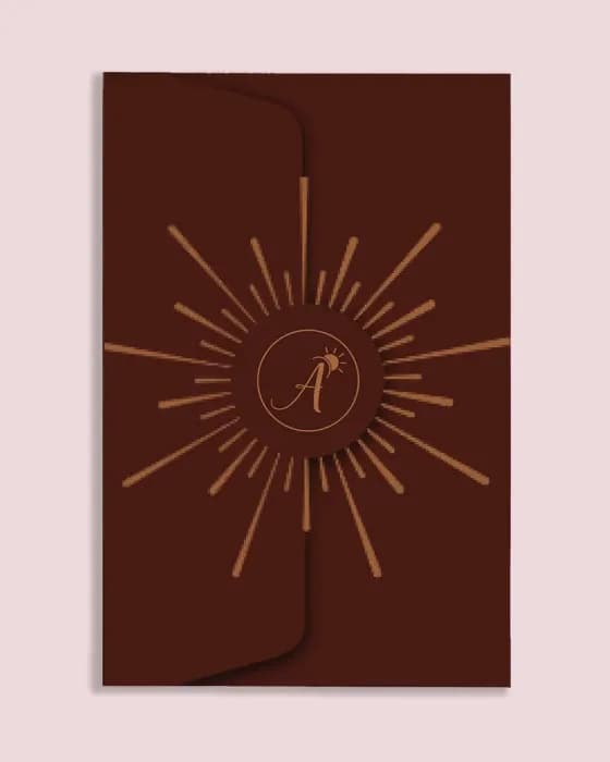 The brown Auralis Hotel key card holder, closed, with a sun motif around an A monogram.