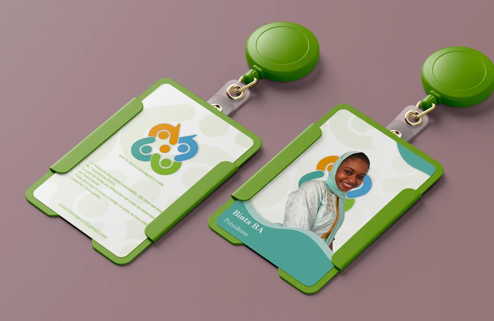 Two PAYA team badges in green holders on a mauve background: the front shows a portrait and the name Binta BA, Présidente; the back carries the association logo.